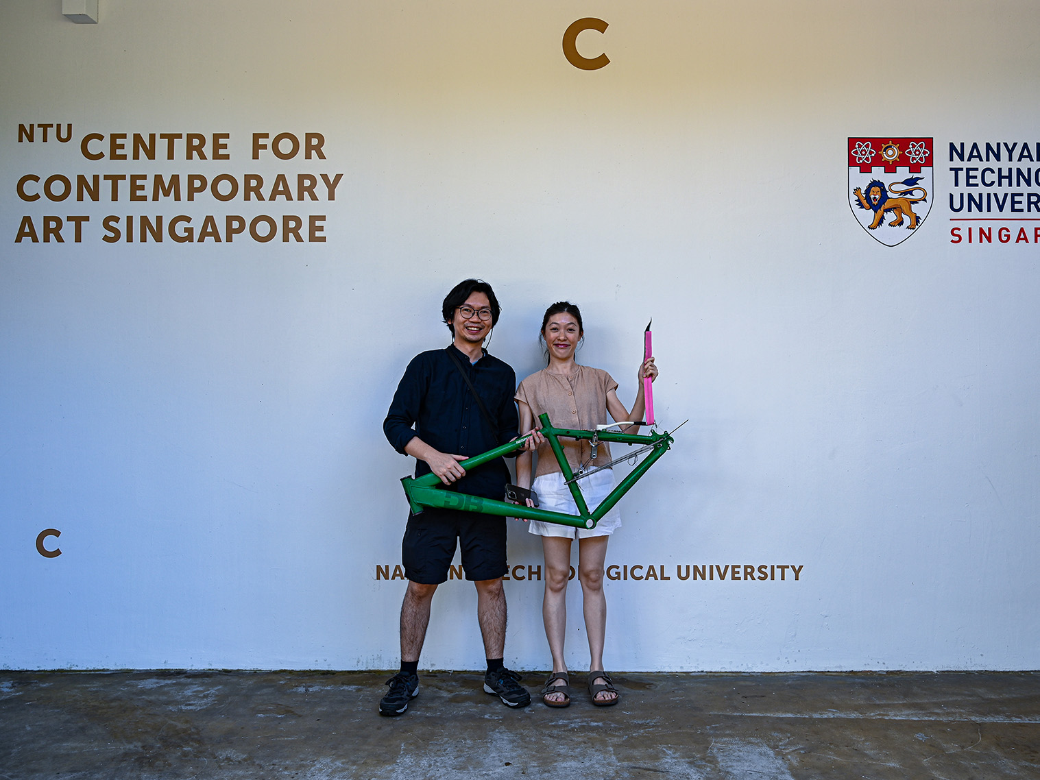 two people holding bicycle parts