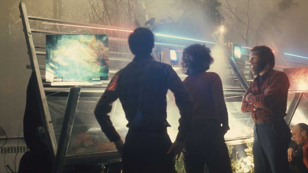 Three men in discussion at an audiovisual production set