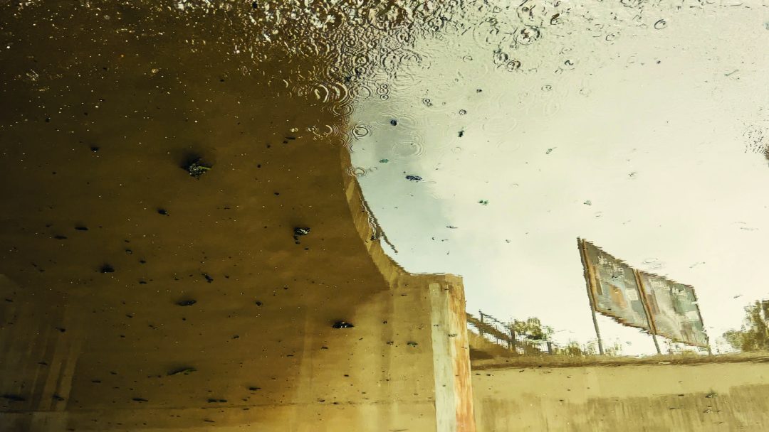 Reflection of urban environment in murky water.